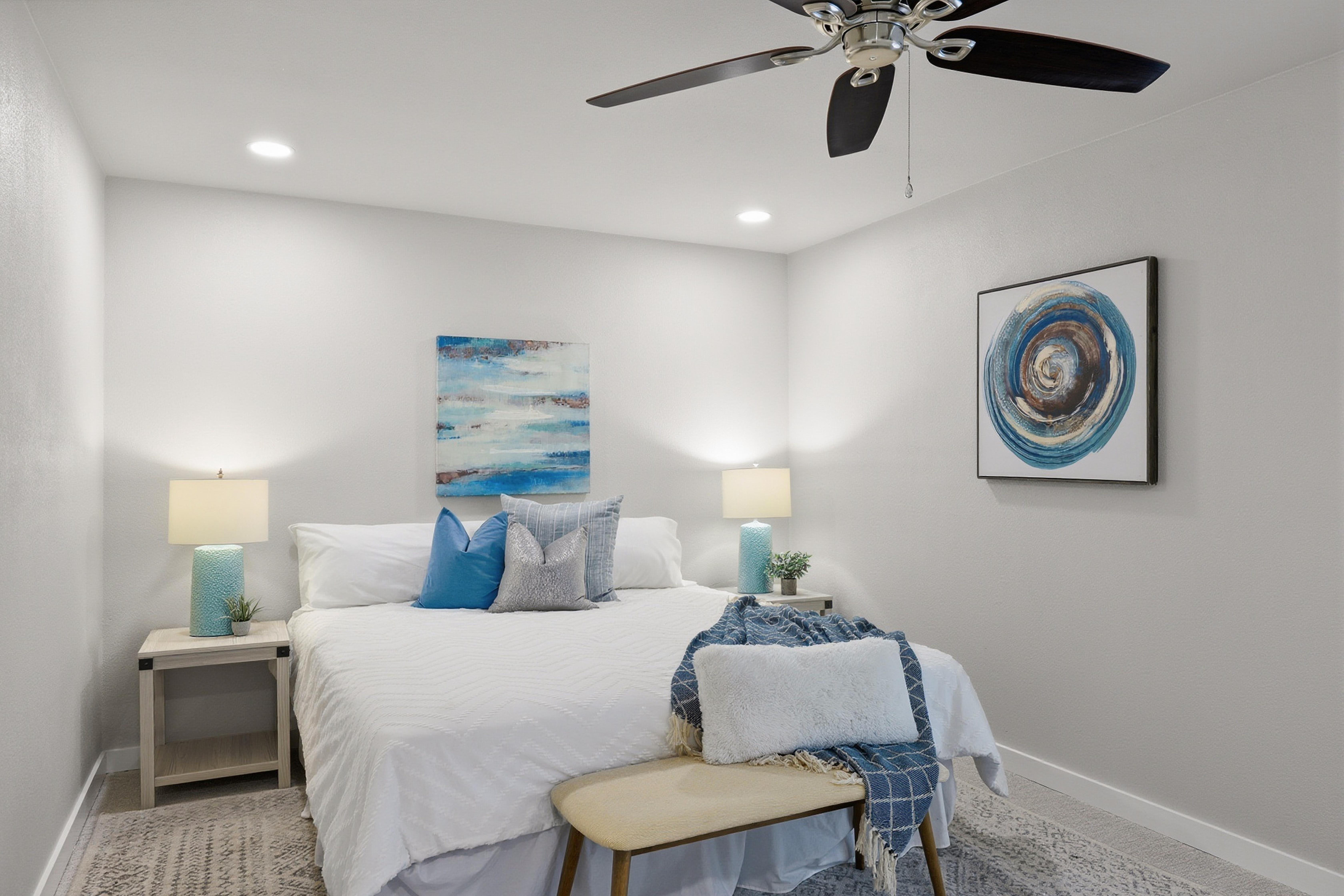 Primary bedroom staged with coastal blue decor and king bed